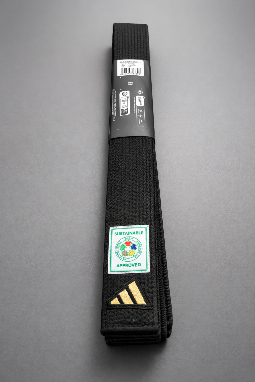 Black Adidas judo belt with its label and packaging