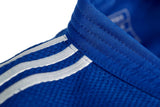 Белые полосы на плече синего кимоно Adidas для дзюдо крупным планом