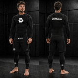 Adult wearing the full branded Gymnasia long-sleeve No-Gi set with shorts over tights, front and back
