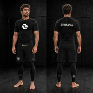 Adult wearing the full branded Gymnasia short-sleeve No-Gi set with shorts over tights, front and back