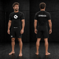 Adult wearing the branded Gymnasia short-sleeve rashguard with shorts, front and back